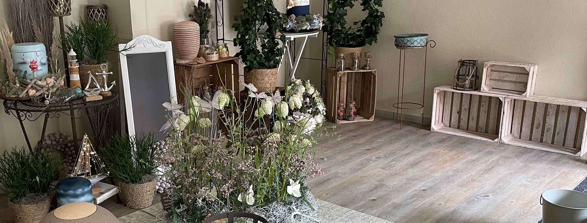 Ein liebevoll gestalteter Raum bei Flenker Bestattungen in Kiel mit Pflanzen, Trockenblumen und Urnen zur individuellen Abschiedsgestaltung.